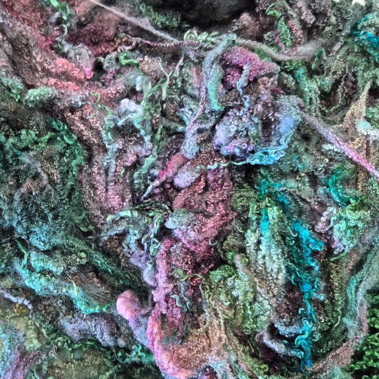 A pile of green and purple dyed curly Bluefaced Leicester Fleece