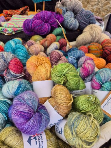 Baskets of hand-dyed skeins of sock yarn and hand-dyed yarn in purple, blue, green, pink, orange and yellow